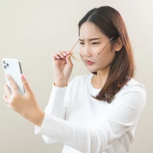 Woman looking at her phone squinting
